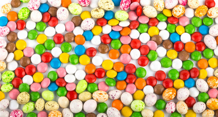 Fototapeta na wymiar Easter holiday colorful background of colorful round candies and candies similar to birds eggs