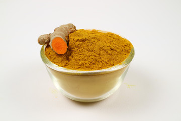 Turmeric and root powder extracted in a glass cup on a white background. Used as a tonic for body and food ingredients.