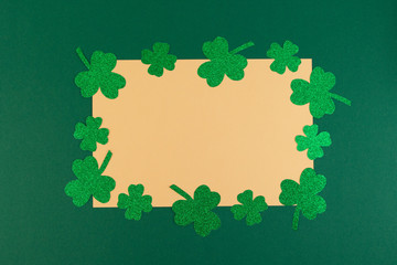 St.Patrick 's Day. Clover shamrocks frame on a green background. Copy space, flat lay