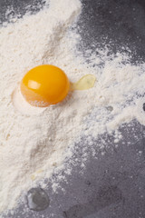 flour and broken egg on a black background close-up