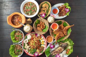 mixed thai isan food on black table