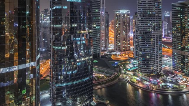 Residential and office buildings in Jumeirah lake towers district night timelapse in Dubai. Aerial panoramic view from above with modern skyscrapers