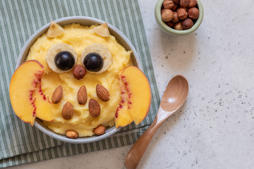 Kids breakfast polenta porridge with fruit look like a cute owl