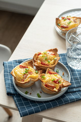 Baked egg, ham, tomato and toast cup for breakfast brunch.