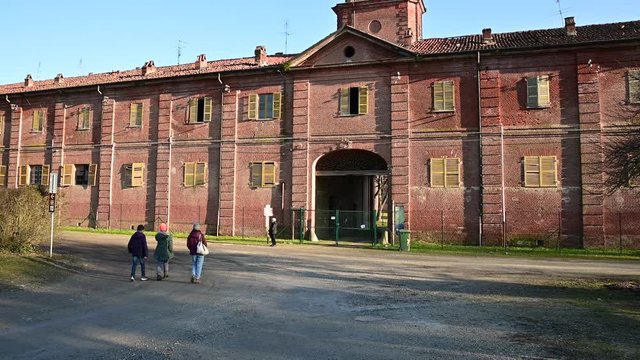 Venaria Reale, Piedmont, Italy. January 2020. "La Mandria" regional park, view of the royal hunting lodge. View of the rear entrance, a long avenue with a dirt road leads to it. Red brick facade.