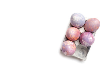 Egg box with easter eggs on white top view
