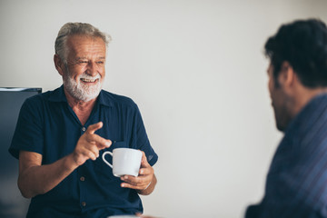 Father-son bonding. Cheerful young man drinking coffee together with him