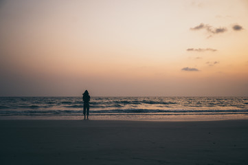 silhouette of the lonely man and the sea during sunset