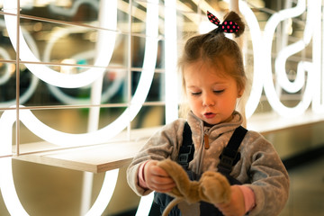 Portrait of a little girl on the background of luminous stripes,