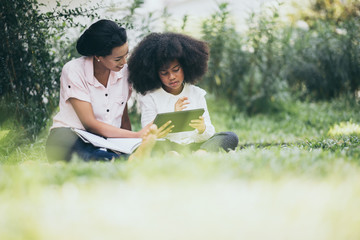 Mother is teaching daughter's homework through Tablet