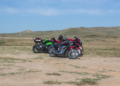 Motorcycles in a hilly field