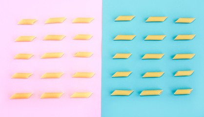 natural long tubular pasta on a pink and blue background