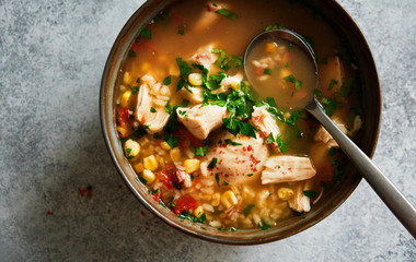 Homemade chicken soup with vegetables and rice in bowl, top view. Close up.