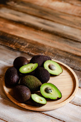 Fresh ripe delicious avocado cut in half on a wooden plate. Natural organic tasty product. Rustic...