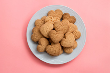 heart cookies in white plate on pink background
