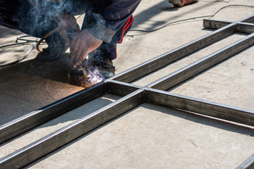 The welder is working on welding. Sparkling and Smoke