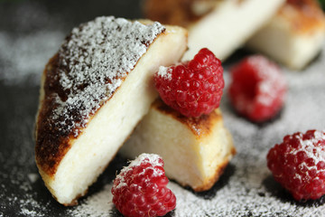 Breakfast. Cheesecakes with raspberries on a dark wooden background. Background image, copy space