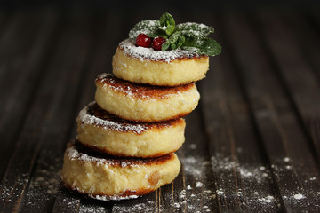Breakfast. Cheesecakes with cranberry and mint on a dark wooden background. Background image, copy space
