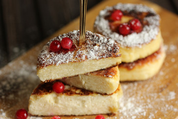 Breakfast. Cheesecakes with cranberry on a light wooden background. Background image, copy space