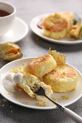 Breakfast. Cheesecakes with sour cream, jam and tea on a light background. Background image, copy space