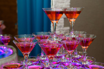 Pile of champagne glasses at a party. Alcoholic luxury pyramid of wineglass.