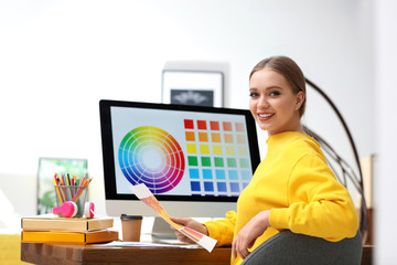Professional designer with color palettes at workplace in office