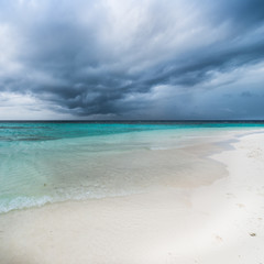 Storm over the ocean. White sand on the beach of a tropical island.