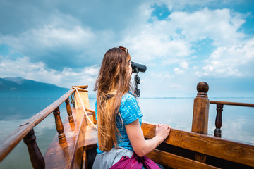 Woman on a boat with binocular watching birds