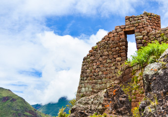 Ancient door in inca town of Pisac in Peru with cloudy sky background