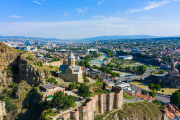 Panorama of the old town on Sololaki hill, crowned with Narikala fortress, the Kura river and cars traffic with blure in Tbilisi, Georgia.