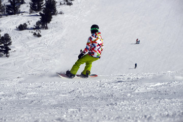 A snowboarder an a ski driver on the piste in Bansko, Bulgaria.