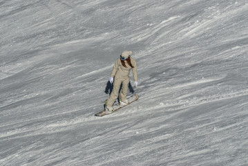 A snowboarder an a ski driver on the piste in Bansko, Bulgaria.