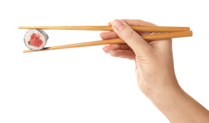 Woman holding sushi roll on white background, closeup