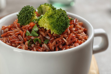 Tasty brown rice with broccoli on table, closeup