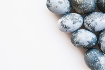 Natural dyed gray blue colored eggs on white background, top view.