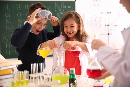 Smart pupils making experiment in chemistry class - Powered by Adobe