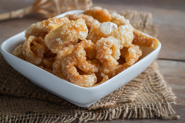 Pork rind, pork crackling in white bowl.