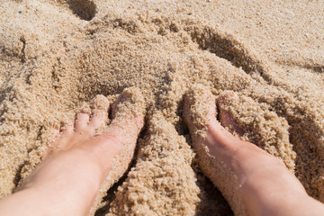 feet in the sand on the seashore