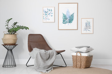 Comfortable armchair and plant near white wall indoors at home. Idea for interior design