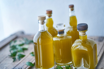 Closeup of glass bottles filled with golden liquid juice or oil. Health cooking in mediterranean kitchen good for wellness and body relaxed summer feeling