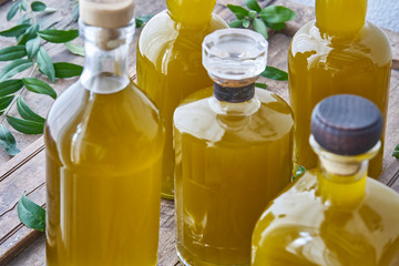 Closeup of glass bottles filled with golden liquid juice or oil. Health cooking in mediterranean kitchen good for wellness and body summer feeling