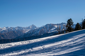 Amazing view of snow clad mountain landscape during Kedarkantha winter trek in Uttarkashi, Uttarakhand (India). Trek in December on Christmas and New Year