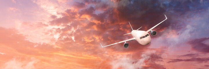 Airplane in the cloudy sky at sunset - Passenger Airliner or aircraft