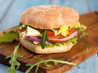 sandwich with ham vegetables and cheese with herbs.