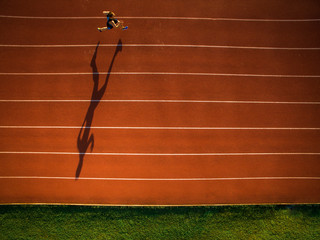 Shot of a young male athlete training on a race track. Sprinter running on athletics tracks seen...