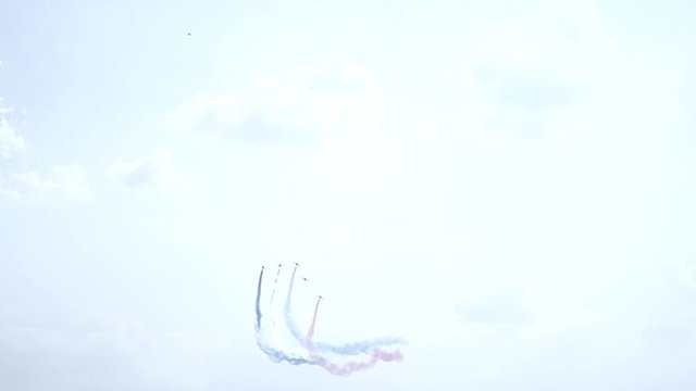 Five fighter jets in the blue sky. Blue, red and white colors. A general plan. Aerobatic figures. Airshow. 10 seconds