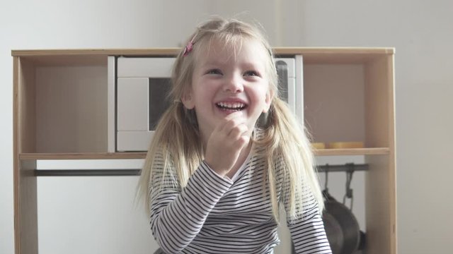 Funny little girl shows on her fingers that she is 4 years old.