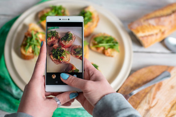 a person takes pictures with her phone, photographs healthy food