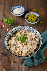 Russian traditional salad Olivier with vegetables and sausage