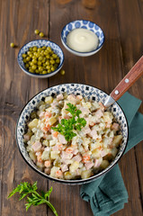Russian traditional salad Olivier with vegetables and sausage